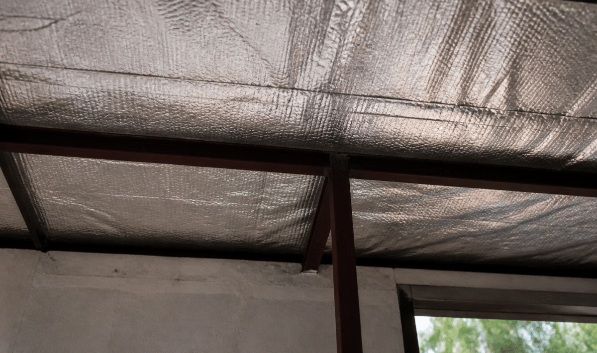 Isolant thermique applique sous tole metallique depuis interieur batiment