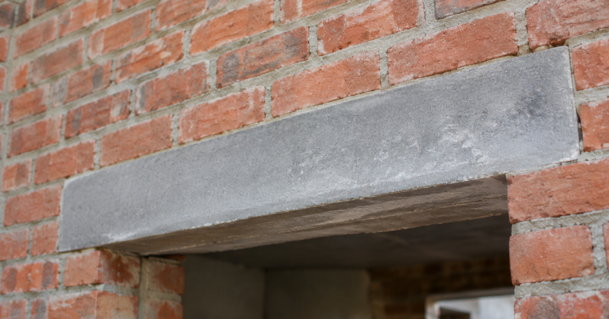 Linteau beton gris reposant horizontalement dans mur brique