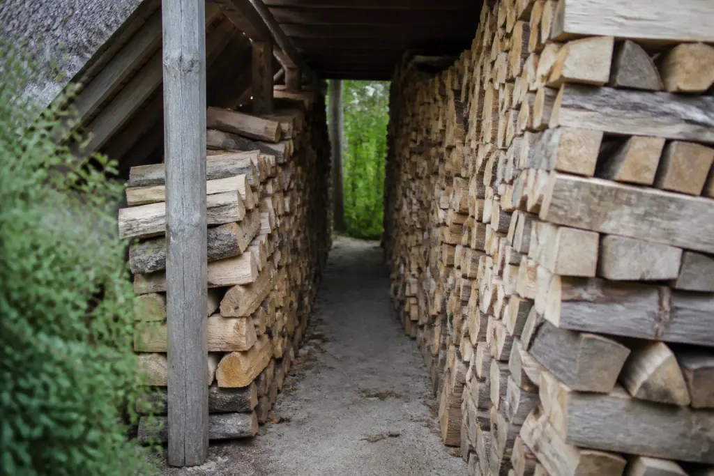 Deux piles de bois alignees sous un abri